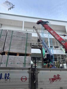 Vận chuyển các kiện gạch lên tầng bằng xe cẩu